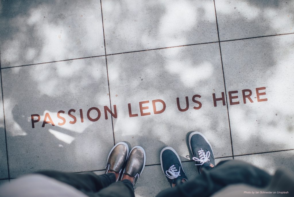 Photo montrant les pieds de deux personnes sur un sol carrelé portant l'inscription "Passion led us here".